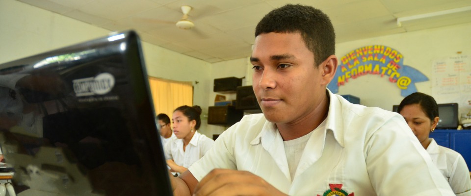 Foto de un joven observando un computador